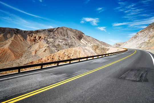 Deserted mountainous terrain with empty highway, travel concept, USA.