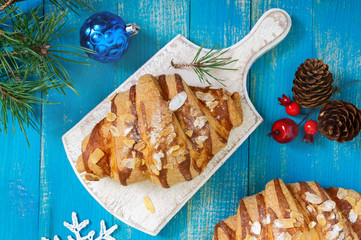 Croissants with almond flakes on a blue wooden background. Breakfast. Traditional French pastries.