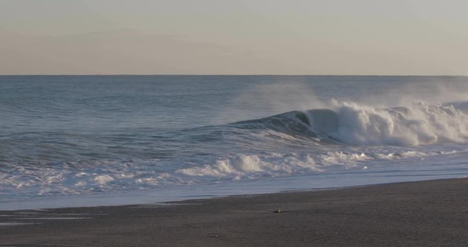 Oceano e mare mosso in tempesta con onde impetuose che si infrangono sulla spiaggia.
