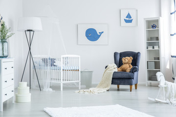 Crib between armchair and lamp
