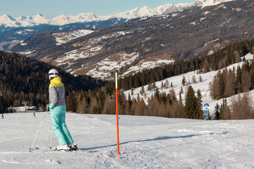Skier with white Helmet Ready for Skiing in Ski Slope, Italian Dolomites Mountains in background