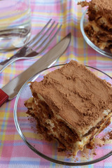 Cake tiramisu - delicious  dessert on a plate, with  another peace of cake on background.