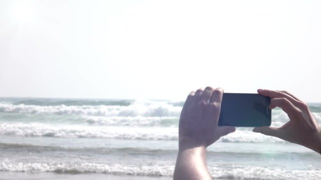 High quality video of man taking a picture of ocean in real 1080p slow motion 250fps