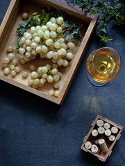 Juicy sweet white grapes in a wooden box on the table. A concept for a wine bar, wineries, wine...