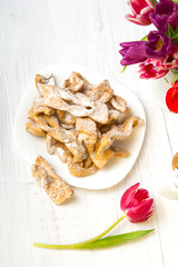 Faworki - tradycyjne Polskie ciastka podawane  w tłusty Czwartek. Deser na białym drewnianym tle. Miejsce na tekst,  © czarny_bez