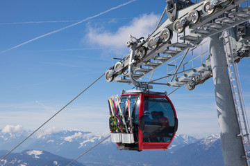  some skiing peole are going with a funicular chair lift to the top of the mountain to do some wintersport