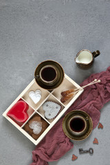 Two cups of coffee and different kinds of heart symbol. A concept for Valentine's Day and other romantic holidays. Top view, close-up on a white vintage wooden background