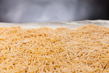 Close up view of raw handmade italian pasta maccheroncini on a wooden table. Black background