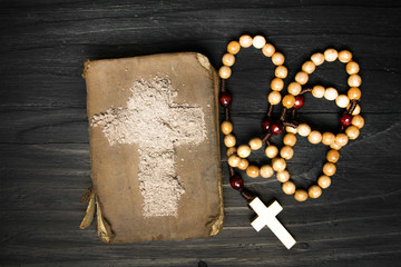 Old Bible, rosary and Cross of ash - symbols of Ash Wednesday.