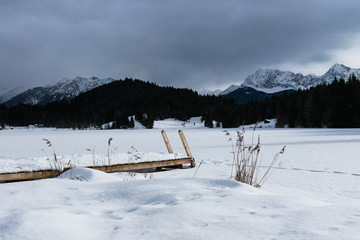 Fototapeta na wymiar eingeschneiter Schwimmsteg mit Leiter am zugefrorenen See