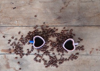 Obraz na płótnie Canvas Two hearth shaped coffee cups on weathered wood