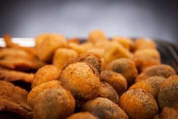 Italian food. Close up view of fried cream and olives ascolane . Typical regional dish. Black background