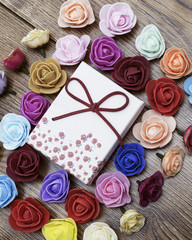 Symbol of Valentine's day. Gift box with group of roses over wooden table. Top view.