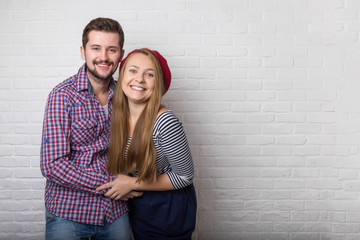 A happy funny couple in love enjoys Valentine's Day. Loft style, brick wall.