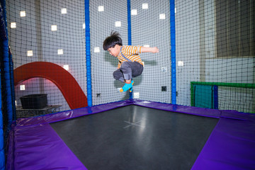 A kid is jumping on trampoline