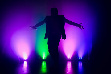 The entertainer. Young elegant talking man holding microphone