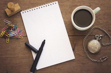 arabic cup coffee and wooden stamp, empty notebook, and pocket watch