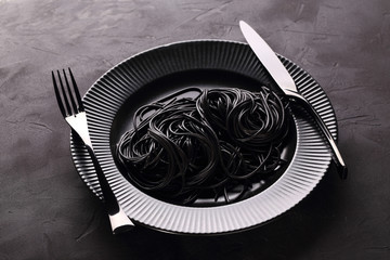 Black pasta in the black plate - 186568250