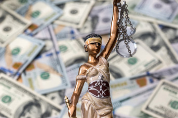 Themis statue standing against the background of dollars