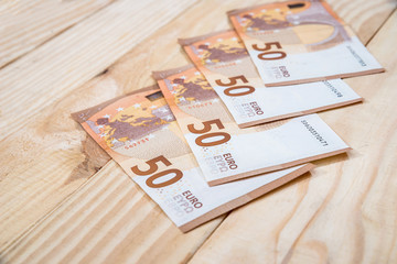 50 new euro banknotes on wooden desk