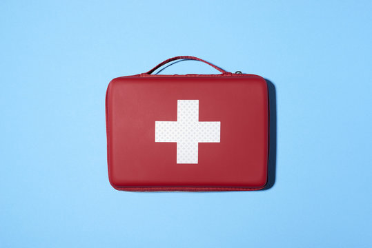 Red medical kit isolated on blue background