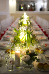 white table set for party with flowers, candle and bulbs