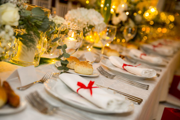 white table set for party with flowers, candle and bulbs