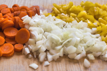 Closeup of Carrots, Onions and Peppers on Cutting Board