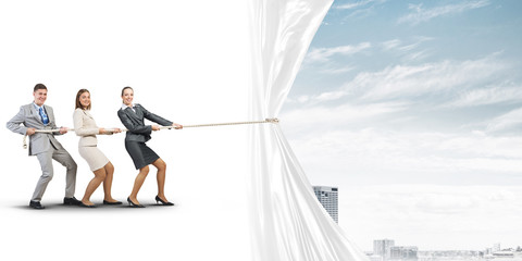 Young businesspeople working in collaboration and pulling white advertisement banner