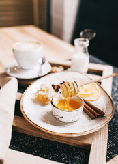 beautiful layout: bottle of milk ,honey, honey stick , nuts and coffee on a gray napkin