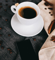 beautiful layout: coffee, cinnamon sticks and coffee beans on gray textiles