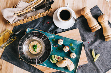 beautifully served meal layout: pike caviar on ice with butter and bread and a cup of coffee