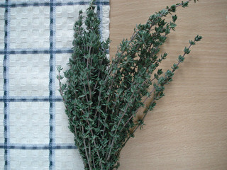 Thyme against the background of the table, near the napkin. Thyme branches, top view.