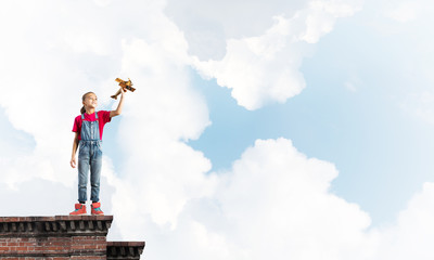 Concept of careless happy childhood with girl dreaming to become pilot