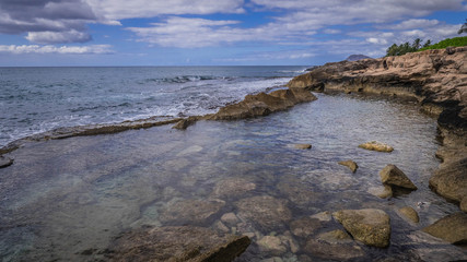 Fototapeta na wymiar Waves Crashing against rocks on the Hawaiian coastline