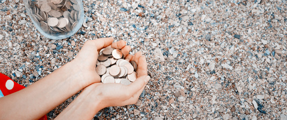  Handful of coins in palm female hands. Concept of saving and passive income