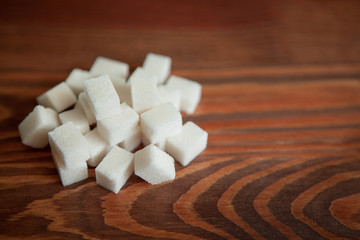 Sugar cubes on wooden background with copy space