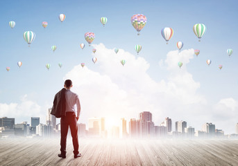 Motivation and inspiration concept with modern cityscape and businessman observing it