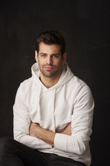 Studio shot of a handsome young man against dark grey background 