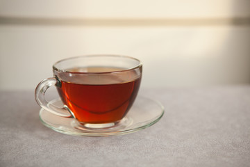 Glass cup of black tea on gray table