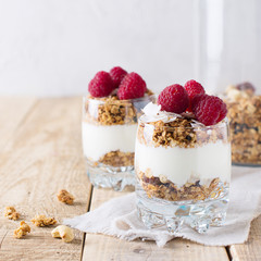 Healthy breakfast with oats granola,raspberry and nuts over wooden table