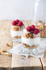 Healthy breakfast with oats granola,raspberry and nuts over wooden table