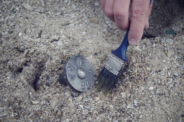 hand with a brush near the old find