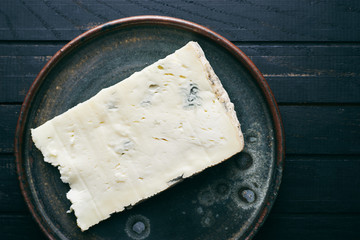 Fresh organic Italian cheese Gorgonzola on plate top view - obrazy, fototapety, plakaty