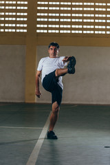 Senior Brazilian or Latin man wearing white blank shirt doing exercises at sports gym