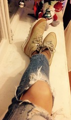 женские ноги в ботинках и рваных джинсах