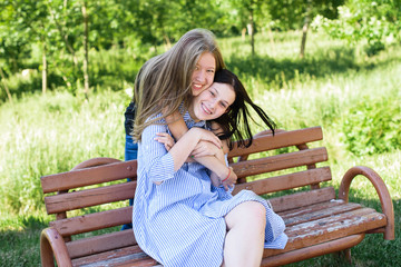 two friends are glad in the park on the bench