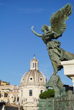 Angel Statue at Monumento Nazionale a Vittorio Emanuele II overlooking the Nome de Maria al Foro Traiano Church at the Trajan Forum in the city of Rome, Italy