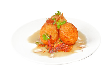 Fried hard-boiled eggs with tamarind sauce .