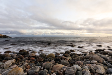 Fototapeta na wymiar Pebble shore at Hove, Tromoy in Arendal, Norway. Raet National Park. Long exposure.